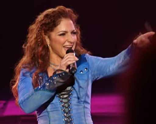 Gloria Estefan live in concert pointing to a fan